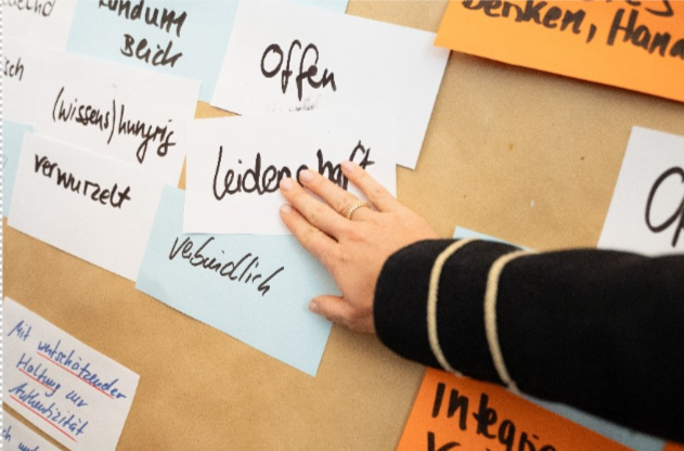 Hand resting on corkboard