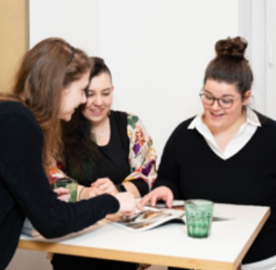 Three women looking at a magazine