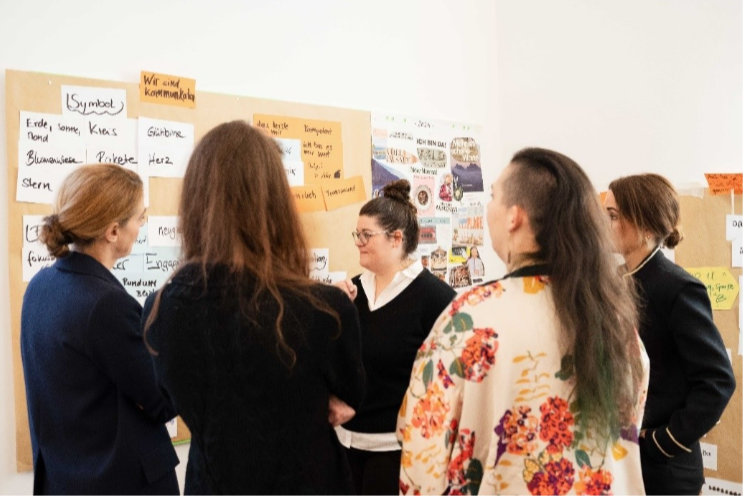 Group of business professionals standing together in a group around a cork board