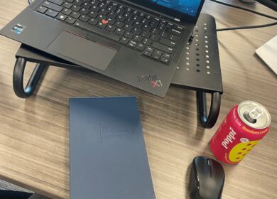 Desk setup with a laptop, mouse and notebook